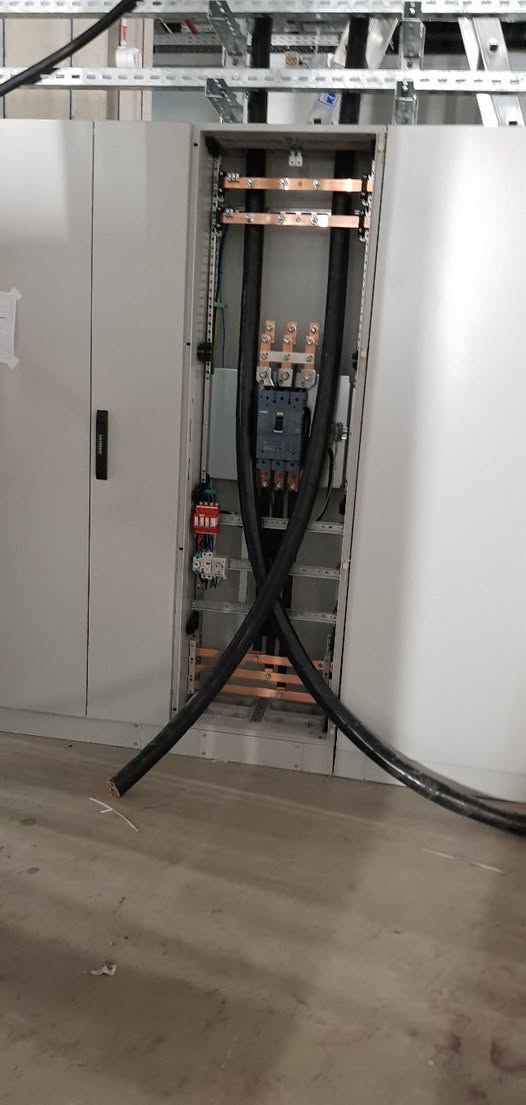 Wnętrze dużej szafy rozdzielczej z miedzianymi szynami zbiorczymi i podłączanymi grubymi kablami zasilającymi 4x240mm2 w obiekcie przemysłowym Zeiss.